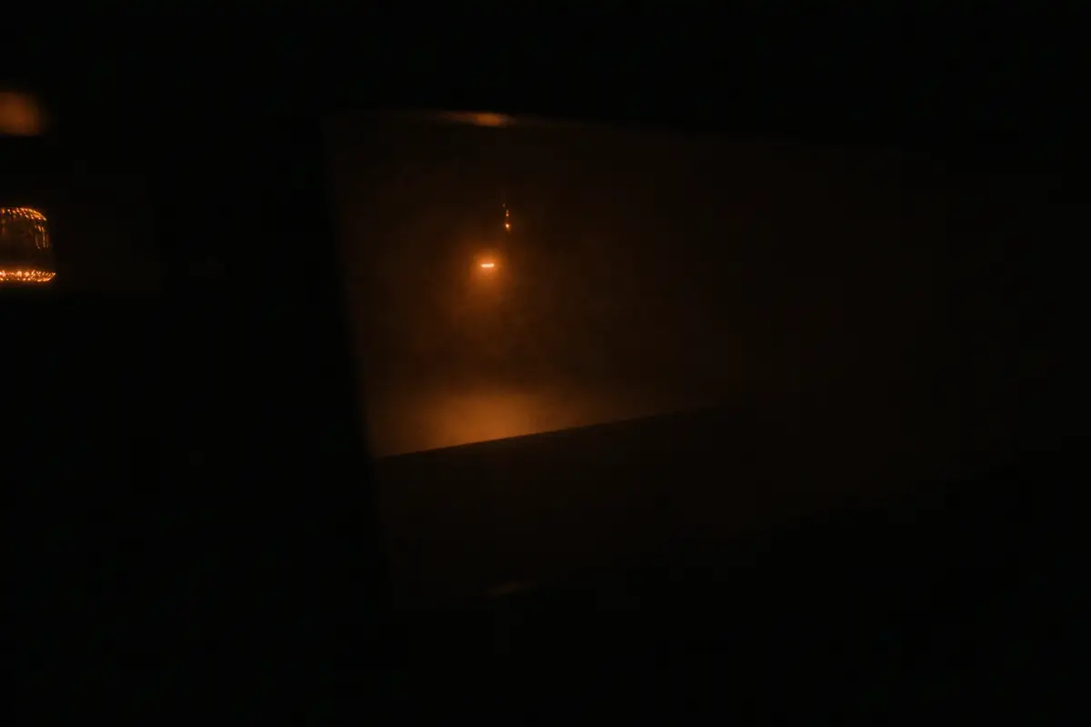 A single warm lamp lighting an empty dark room